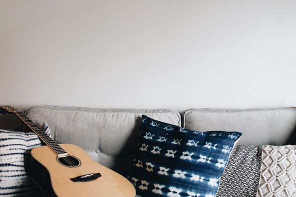Titre - Haley Power Alt - guitare et coussins sur un canapé gris